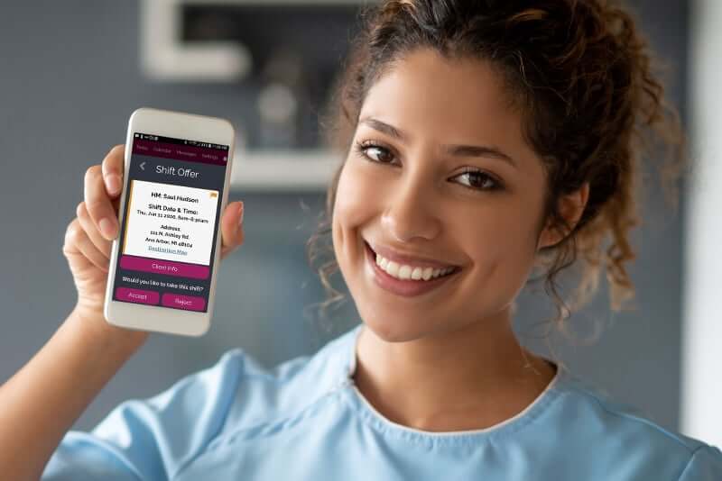 Caregiver showing off the Rosemark System caregiver mobile app for evv