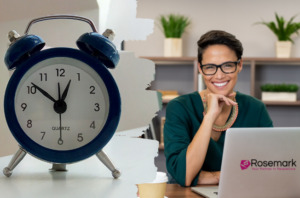 A woman working at a computer with the Rosemark logo on it, next to an image of an alarm clock