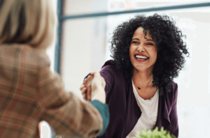 Home care agency owner smiling and shaking hands with a referral partner