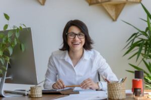 A happy Rosemark customer using her computer to download reports to leverage data to grow her homecare agency