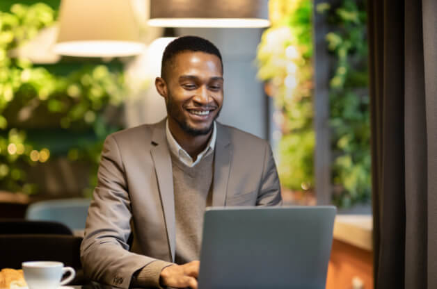man sitting at his desk looking at his KPIs for growth on his computer