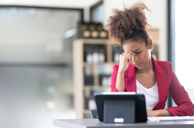 Stressed businesswoman looking at a tablet, representing challenges in business growth.