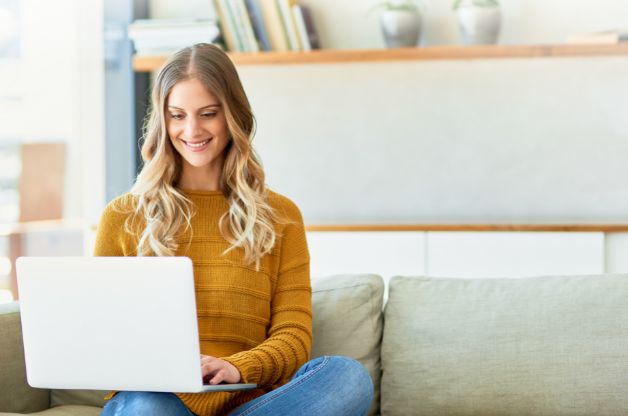 Home care agency owner smiling while managing a smooth QuickBooks Online transition on a laptop.