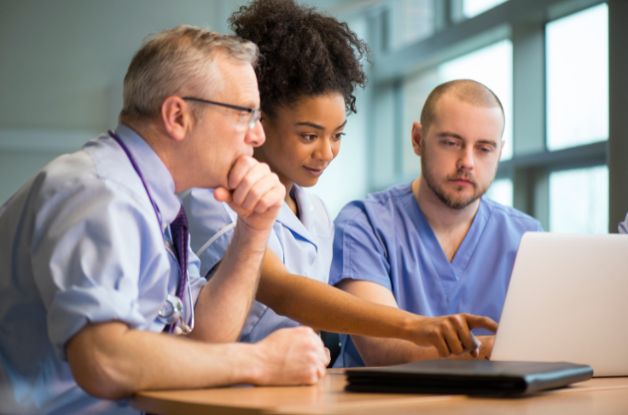 A home care agency manager reviews a written AI use policy with office staff during a team meeting.